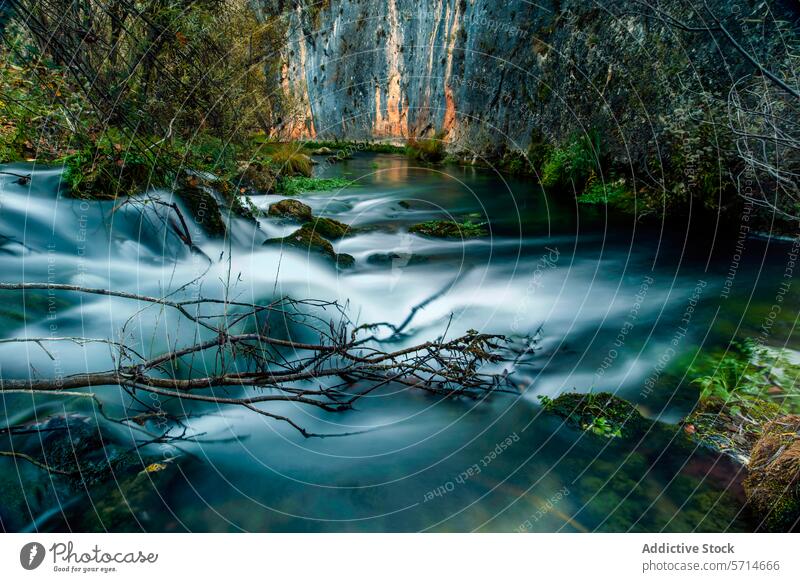 Seidiges Wasser fließt durch den Fluss Escabas in Cuenca, umrahmt von felsigen Klippen und überhängenden Ästen fließen seidig sanft Ast Natur malerisch