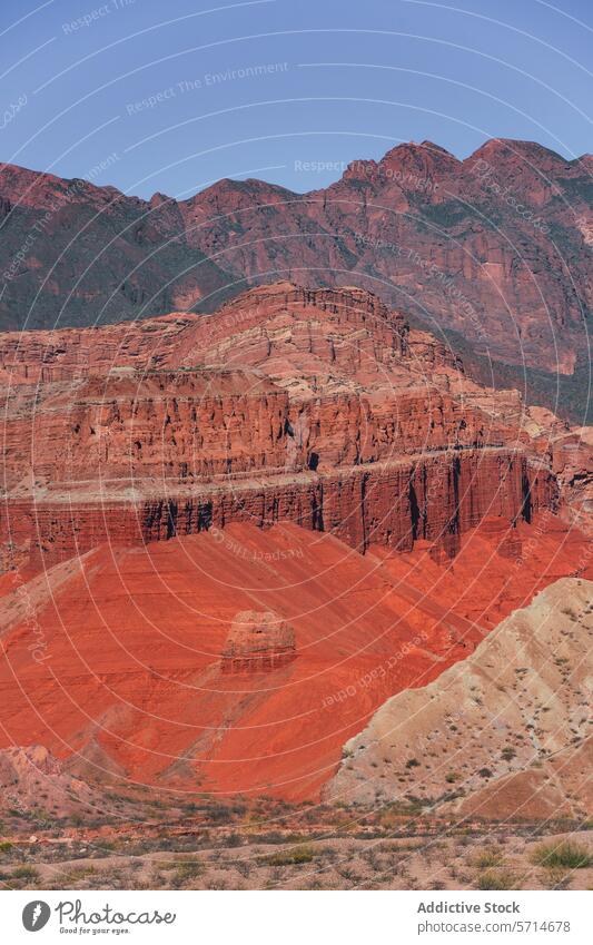 Schichten von roten und orangefarbenen Sedimentgesteinsformationen heben sich von der zerklüfteten Kulisse von Los Castillos ab. sedimentär Ebene Felsen