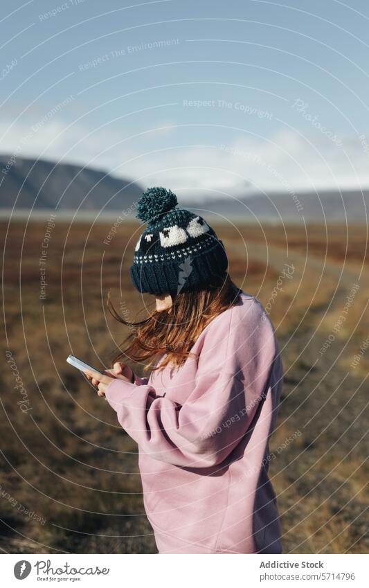 Frau benutzt Smartphone in malerischer isländischer Landschaft Island reisen Natur Tal Technik & Technologie im Freien Erkundung Fernweh abgelegen Konnektivität