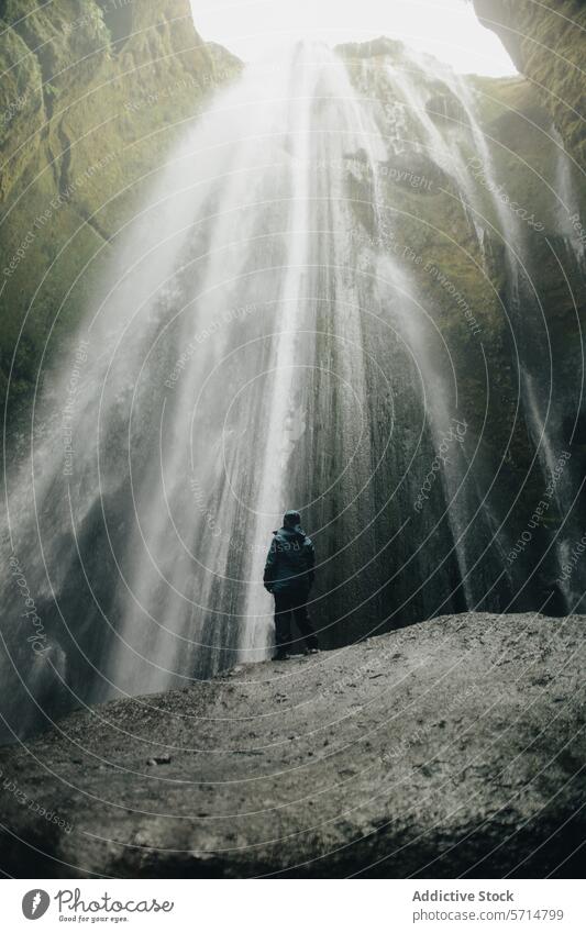 Mann beim Anblick des atemberaubenden Wasserfalls Gljúfrabúi Island gljúfrabúi Jacke blau Natur reisen majestätisch Landschaft Abenteuer Erkundung im Freien