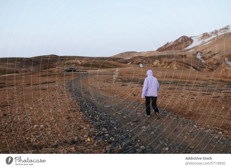 Frau erkundet die einsamen Landschaften Islands reisen Abenteuer unfruchtbar Hügel Schotterweg rosa Jacke laufen erkunden Gelände Off-Road suv geparkt abgelegen