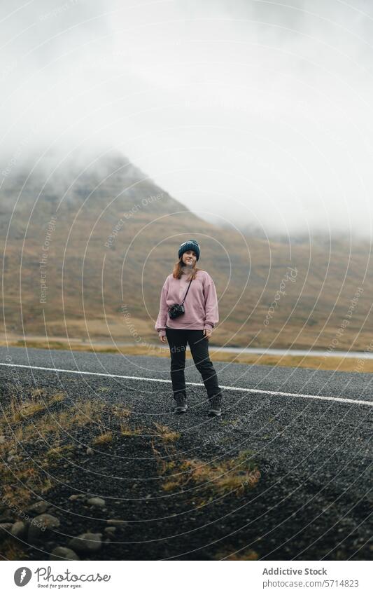 Weibliche Reisende auf einer nebligen isländischen Straße Island Frau reisen Berge u. Gebirge Nebel Landschaft Abenteuer solo Natur im Freien Menschenleer