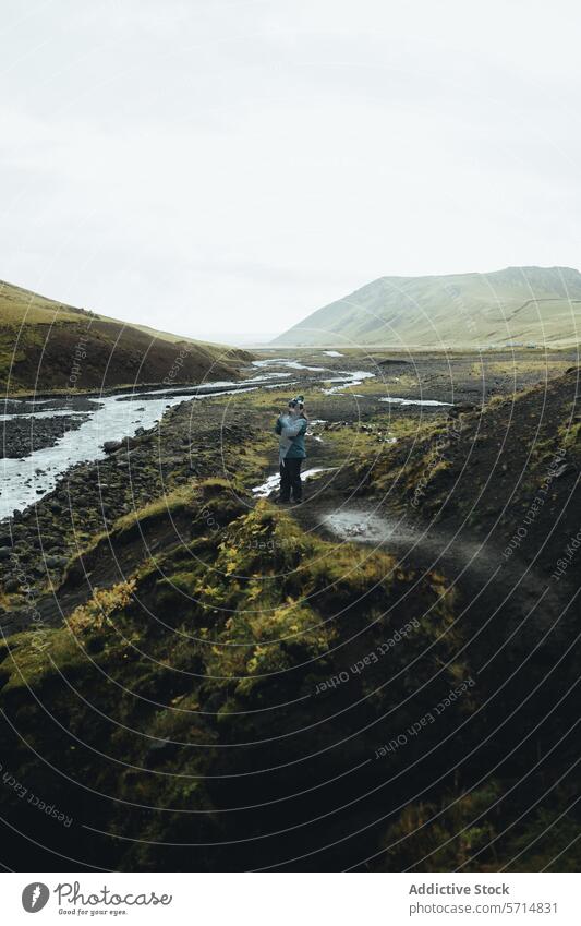 Mann erkundet weites isländisches Tal auf dem Fluss Island reisen Erkundung männlich grün Hügel Gelassenheit Fernweh Reise Natur im Freien Landschaft Abenteuer