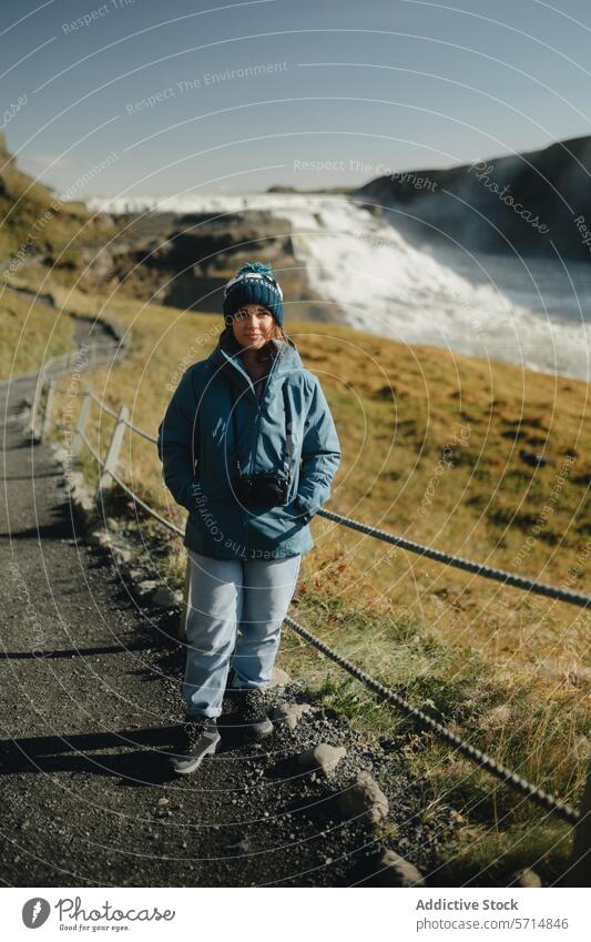 Weibliche Reisende am Gullfoss-Wasserfall in Island reisen Frau im Freien Weg Natur Landschaft Nebel Tourist Abenteuer Erkundung warme Kleidung Hut Jacke