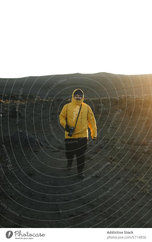 Mann in gelber Jacke erkundet isländisches Terrain Island Entdecker vulkanisch Landschaft Sonnenuntergang Fotograf Fotokamera männlich reisen Abenteuer Natur