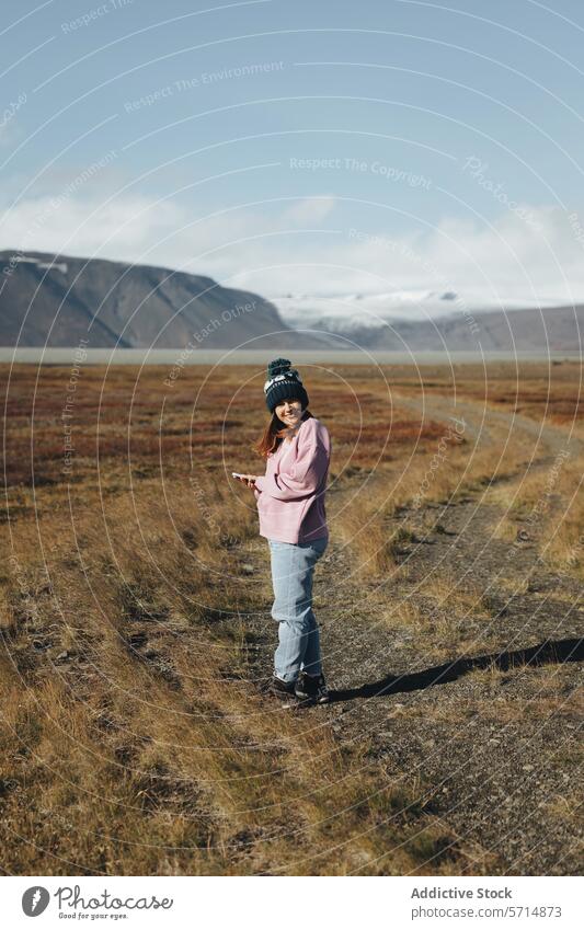 Glückliche Frau mit Smartphone in malerischer isländischer Landschaft Island reisen Natur Tal Technik & Technologie im Freien Erkundung Fernweh abgelegen