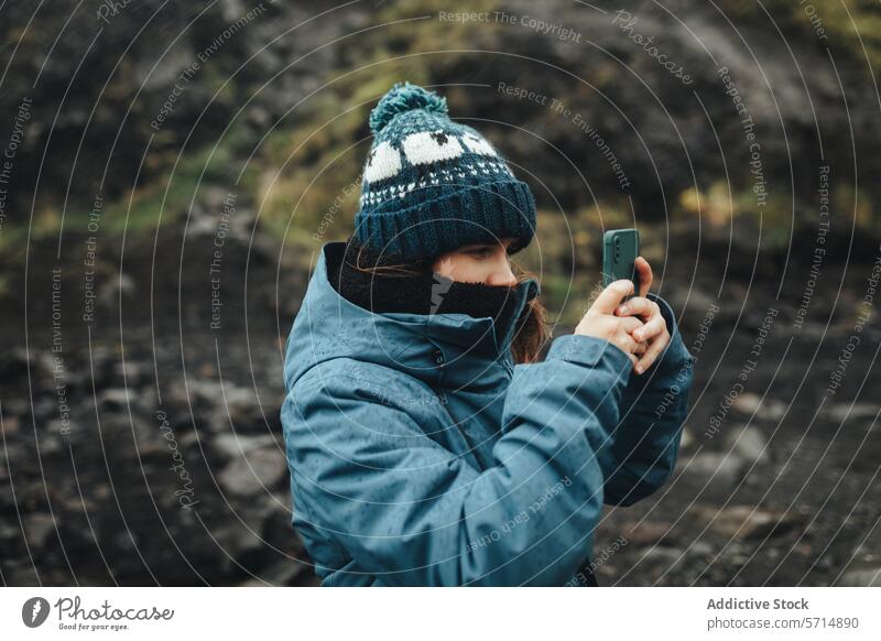 Isländische Landschaften mit Technologie erforschen Islandreise Frau Smartphone Fotografie reisen Erkundung Abenteuer Tourismus Natur im Freien wolkig kalt