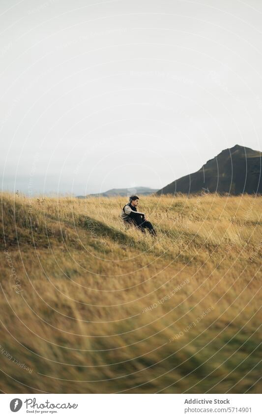 Kontemplierender Mann in ruhiger isländischer Wiese Island Ausflug Kontemplation Einsamkeit Natur friedlich Gelassenheit Hügellandschaft Landschaft reisen
