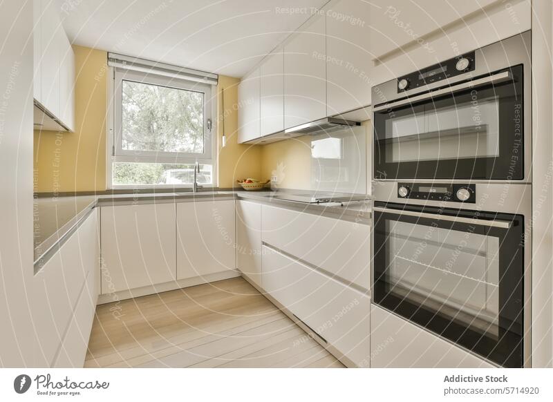 Moderne Kücheneinrichtung mit hellem Tageslicht Innenbereich modern Zeitgenosse Design weiß Schreinerei eingebaut Vorrichtung Sonnenlicht Fenster