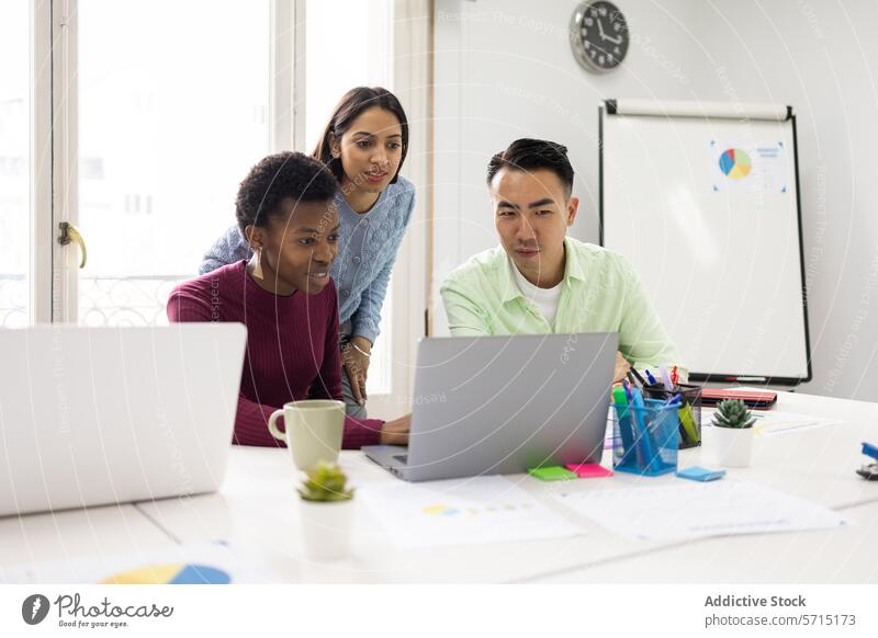 Verschiedene Kollegen besprechen ein Projekt in einem hellen Büro Besprechung Team professionell Arbeitsplatz Laptop farbenfroh Schreibwarenhandlung