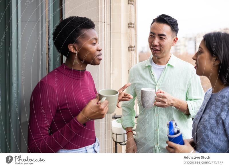 Freundliche Gespräche unter verschiedenen Freunden bei Getränken vielfältig lässig Balkon jung Erwachsene freundlich plaudernd multikulturell sozialisierend