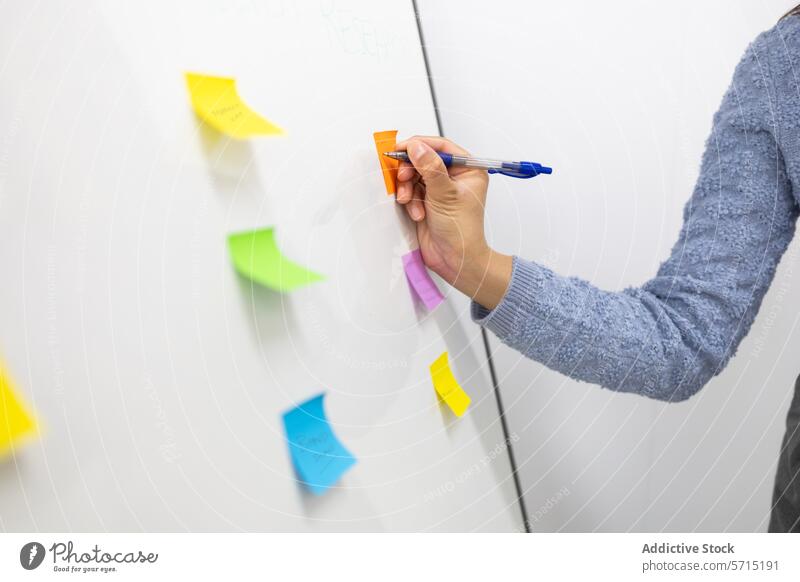 Organisieren von Aufgaben mit bunten Haftnotizen auf dem Whiteboard Person organisierend farbenfroh Büro Arbeit planen Unternehmen Produktivität Management Hand