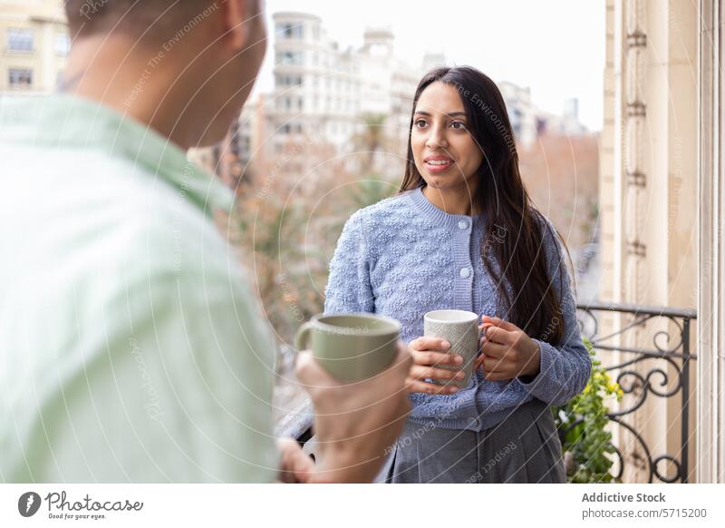Pärchen genießt Kaffee auf einem Balkon mit Blick auf die Stadt Frau Mann Paar Becher Gespräch Lächeln urban Großstadt Gebäude Appartement Freizeit Morgen