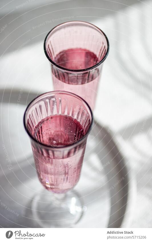 Elegante rosa Gläser auf einem sonnig gedeckten Tisch. Generatives AI-Bild Glas Schatten Licht filigran weiß Getränk Container durchsichtig Eleganz Stil modern