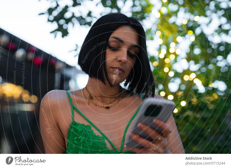 Moderne urbane Frau mit Smartphone in Madrid in der Abenddämmerung vier Türme Bokeh Lichter Stil Kleid grün junger Erwachsener Technik & Technologie Mitteilung