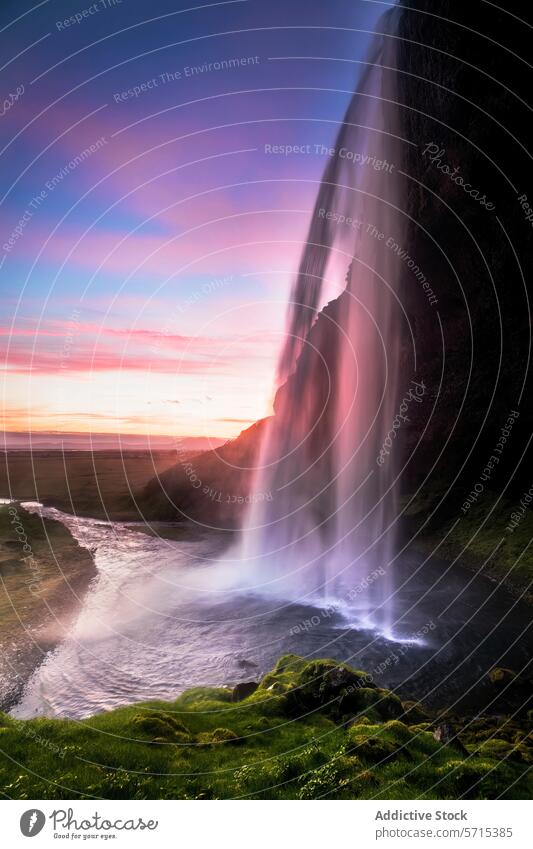 Majestätischer Wasserfall bei Sonnenuntergang in Island Landschaft Natur Schönheit majestätisch Kaskadierung fließen Moos grün Klippen Abenddämmerung Pastell