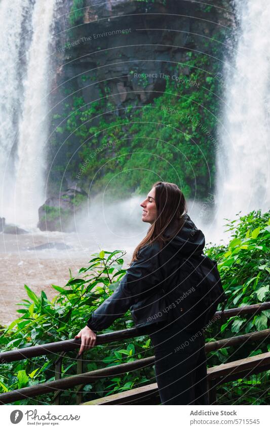 Glückliche Touristin genießt die majestätischen Iguazu-Wasserfälle Frau Wasserfall Nebel Grün Natur reisen Argentinien Beobachtung Abenteuer im Freien