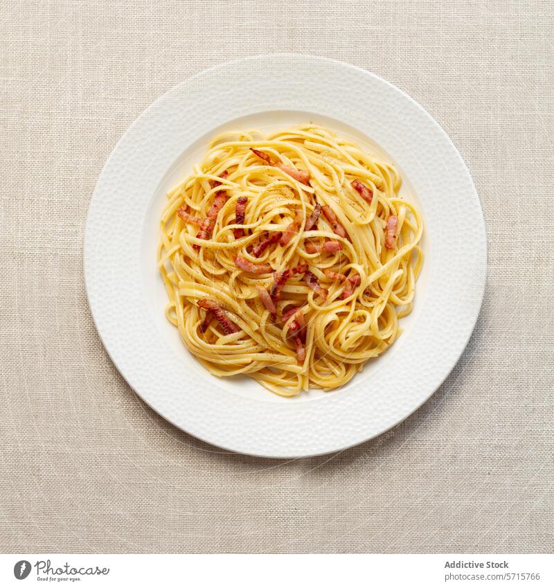 Klassische Spaghetti Carbonara auf weißem Teller Spätzle Italienisch Küche traditionell neutral Tischwäsche Draufsicht Lebensmittel Speise Mahlzeit Speck cremig