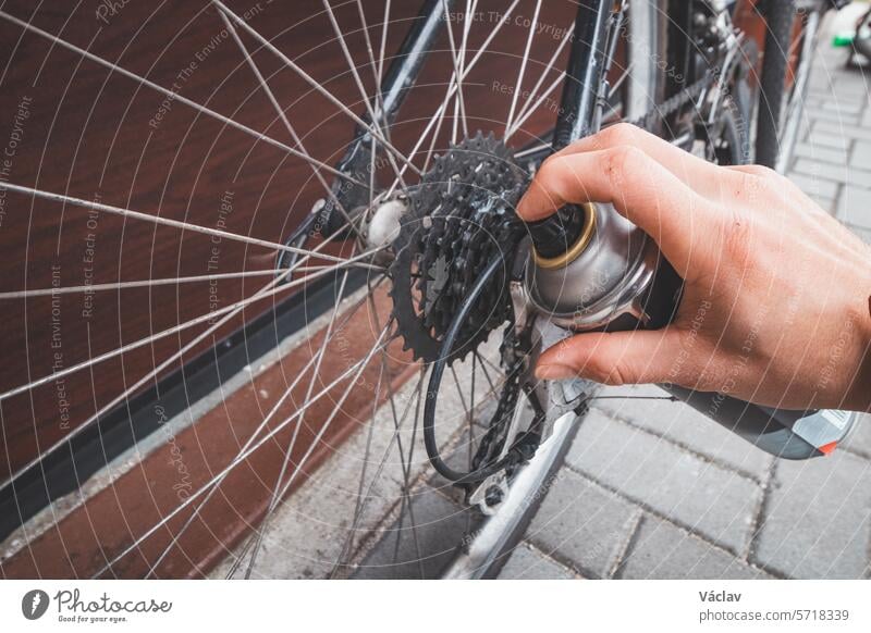 Ein Mann bereitet sein Rennrad auf die Saison vor. Reinigen und Schmieren einer rostigen Kette für eine einwandfreie Funktion. Sport im Freien. Regelmäßige Wartung