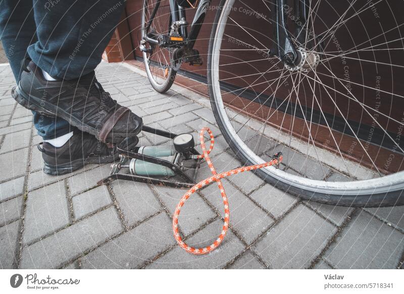 Ein Mann bereitet sein Rennrad auf die Saison vor. Ausblasen des Fahrradschlauchs mit einer Beinradpumpe. Sport im Freien. Regelmäßige Wartung Pumpe Dienst Rad