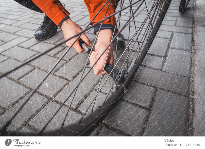 Ein Mann bereitet sein Rennrad auf die Saison vor. Er bläst den Fahrradschlauch mit einer Handpumpe auf. Sport im Freien. Regelmäßige Wartung Pumpe Dienst Rad