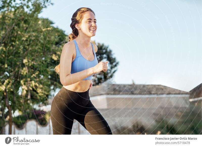 Junge Frau in Sportkleidung beim Laufen im Park im Freien rennen Lifestyle Joggen jung Fitness Übung Läufer Athlet Natur Sportbekleidung Gesundheit passen