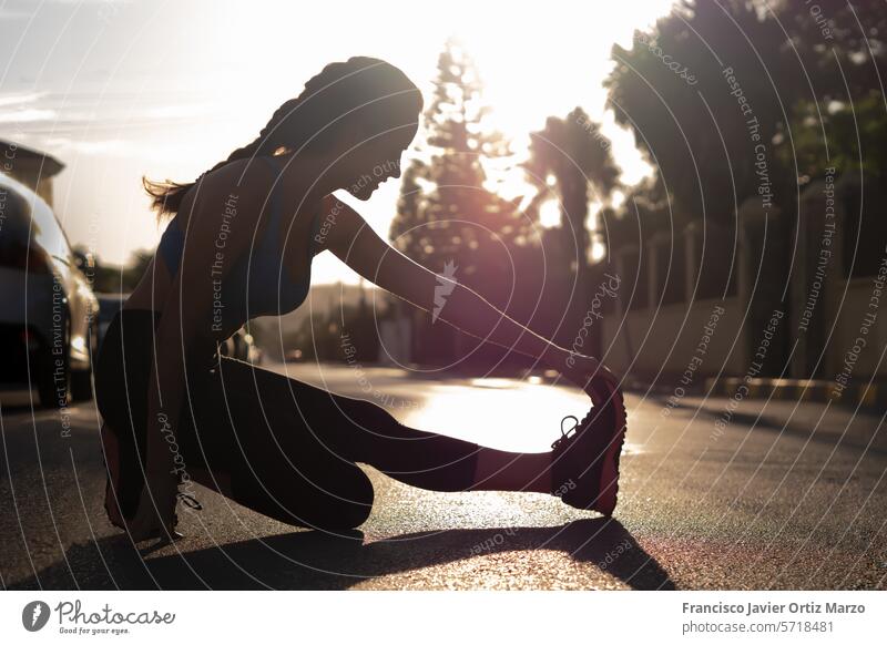 Frau in Sportkleidung beim Stretching auf der Straße. Übung Konzept strecken Fitness Training Lifestyle passen Sportbekleidung Athlet jung Gesundheit trainiert.