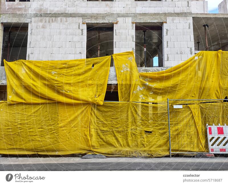 Gelbe Planen hängen vor einem Rohbau rohbau Baustelle Architektur Gebäude Bauwerk bauen Arbeit & Erwerbstätigkeit Wandel & Veränderung Strukturen & Formen