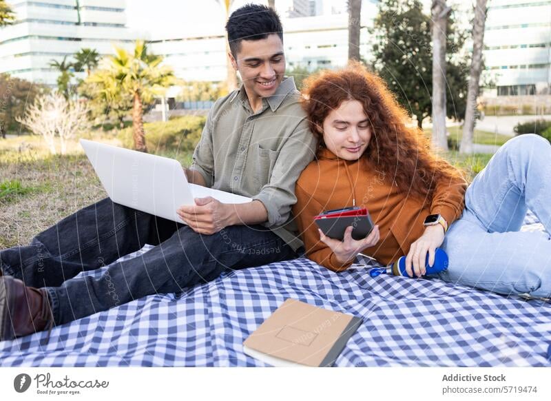 Studenten beim Studieren und Entspannen beim Picknick im Freien Schüler studierend Laptop Notebook Smartphone Mann Frau Vielfalt multiethnisch entspannt lässig