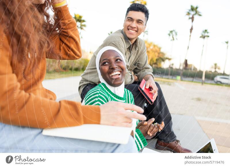 Multiethnische Studenten genießen die Studienzeit im Freien Schüler Park Laptop Smartphone lernen Picknick Frau Mann Vielfalt multiethnisch Freundschaft