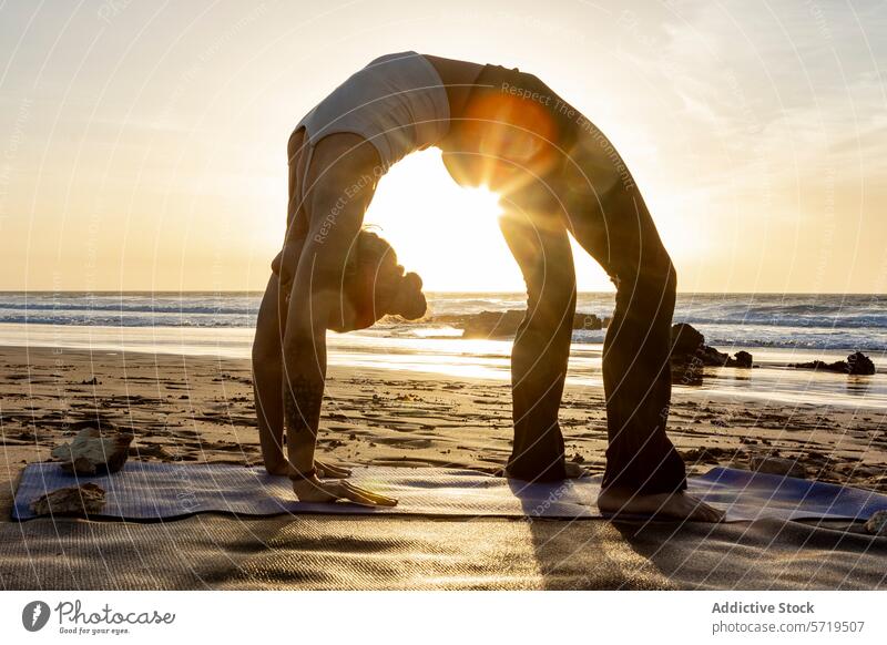 Gelassenes Strand-Yoga mit einer atemberaubenden Rad-Pose bei Sonnenuntergang Gelassenheit Radstellung Backend Dehnung Fitness Gesundheit Wohlgefühl Übung