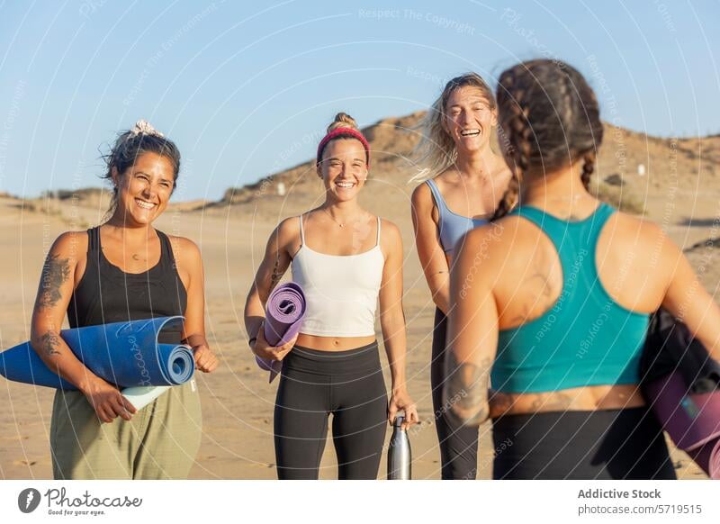 Fröhliche Freunde bereiten sich bei Sonnenuntergang am Strand auf Yoga vor Frauen Klasse Glück vorbereiten Unterlage führen sandig Menschengruppe heiter Fitness