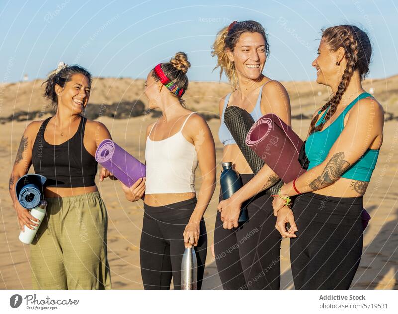 Freunde lächelnd und mit Yogamatten in der Hand am Strand Frauen Lachen tragen Menschengruppe Glück Klasse Übung Fitness Gesundheit Wohlgefühl Erholung Freizeit