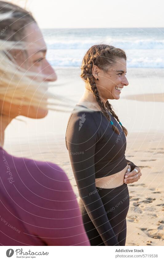 Lächelnde Frauen bei einer Yoga-Sitzung am Strand Sonnenuntergang Klasse freudig friedlich sandig Hintergrund atemberaubend Freizeit Aktivität im Freien Fitness