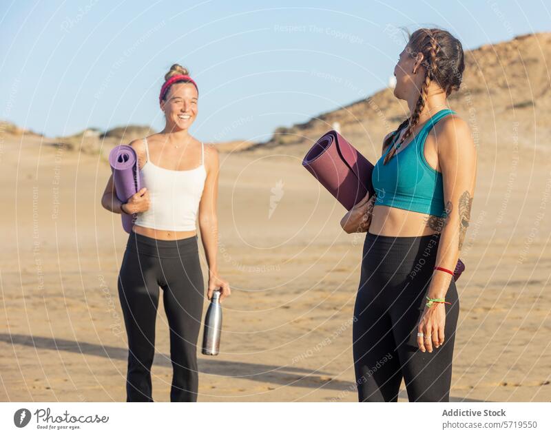 Yoga-Enthusiasten bereit für Strandkurs bei Sonnenuntergang Frauen Lächeln Wellness Freundschaft sandig Vorbereitung Klasse Unterlage Beteiligung Fitness