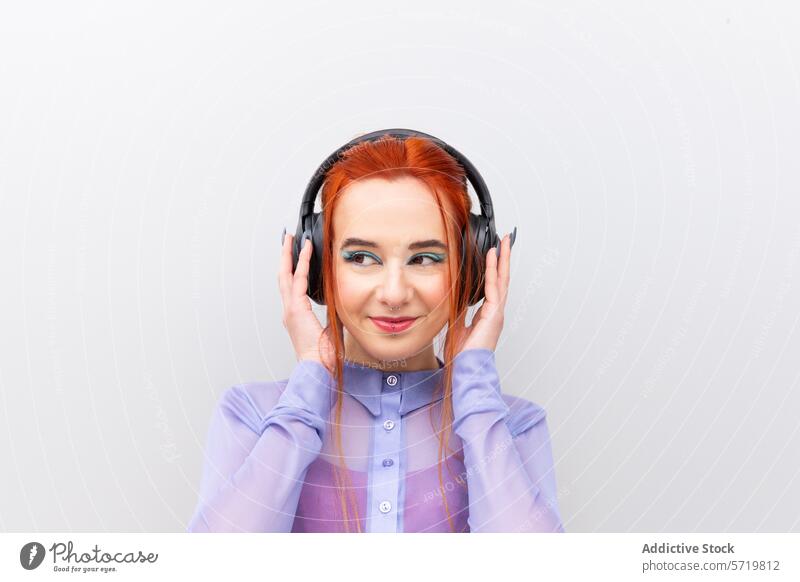Lächelnde Geschäftsfrau mit Kopfhörern genießt Musik Frau hören rote Haare professionell weißer Hintergrund Erwachsener Vergnügen Genuss Erholung Mode modern