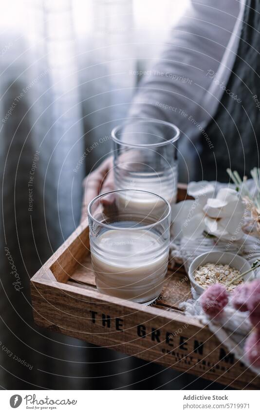 Selbstgemachte Hafermilch in klaren Gläsern servieren selbstgemacht Glas Holztablett Gesundheit Lifestyle Milchalternative milchfrei Veganer Getränk