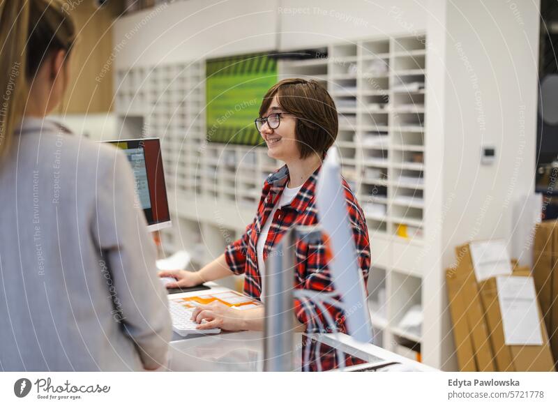 Kundenbetreuung in einem Druckzentrum Lächeln positive Emotion Stehen Dienst Büro Business Mitarbeiter Frau Job Menschen Beruf arbeiten Arbeiter Arbeitsplatz