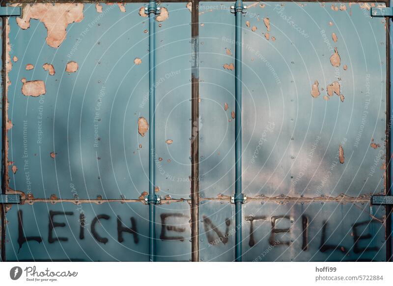 Aufschrift Leichenteile auf einem alten Container Schriftzug Beschriftung Warnung Grafitto abblätternde Farbe grafitti Schriftzeichen Text grafitto Buchstaben