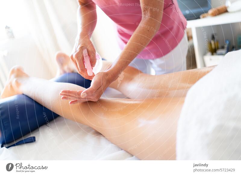 Crop Masseurin tun Körpermassage mit öligen Creme auf Bein des weiblichen Kunden Physiotherapie Massage Osteopath Verfahren Sahne Therapeut Klinik Leckerbissen