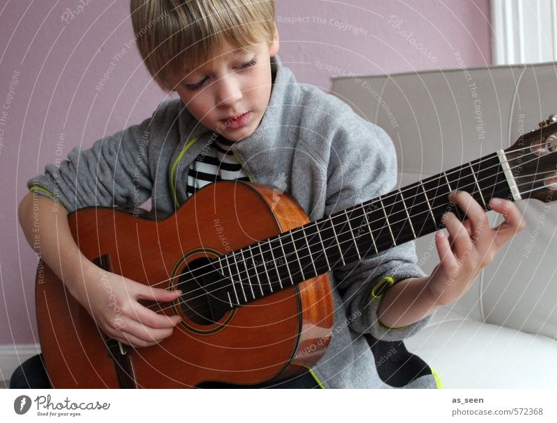 Der Junge mit der Gitarre maskulin 1 Mensch 3-8 Jahre Kind Kindheit Musik Musiker blond Holz berühren hören machen authentisch braun grau rosa weiß Stimmung