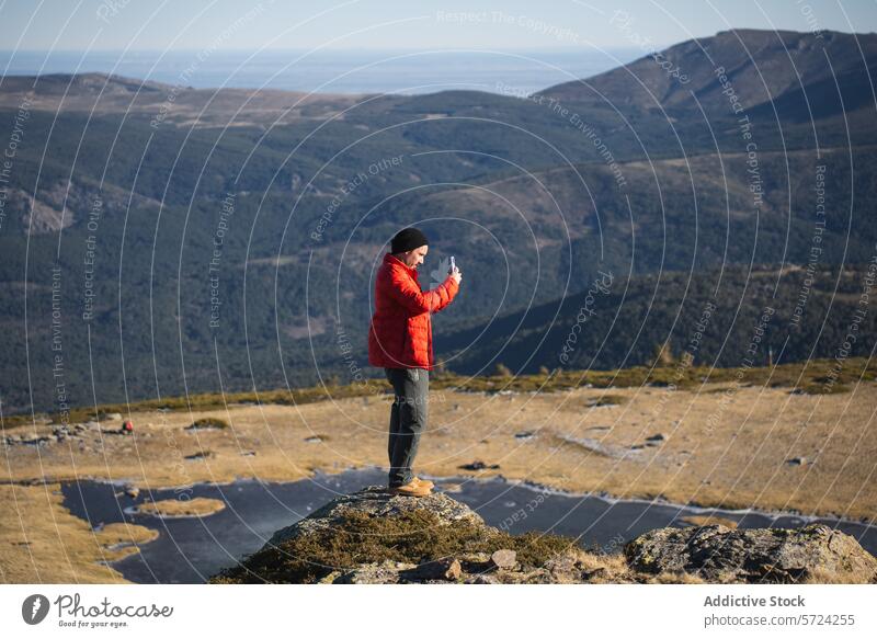 Abenteurer, der auf einem Berggipfel Fotos macht Fotografie Berge u. Gebirge Gipfel rote Jacke Smartphone Natur Landschaft im Freien reisen felsig Person