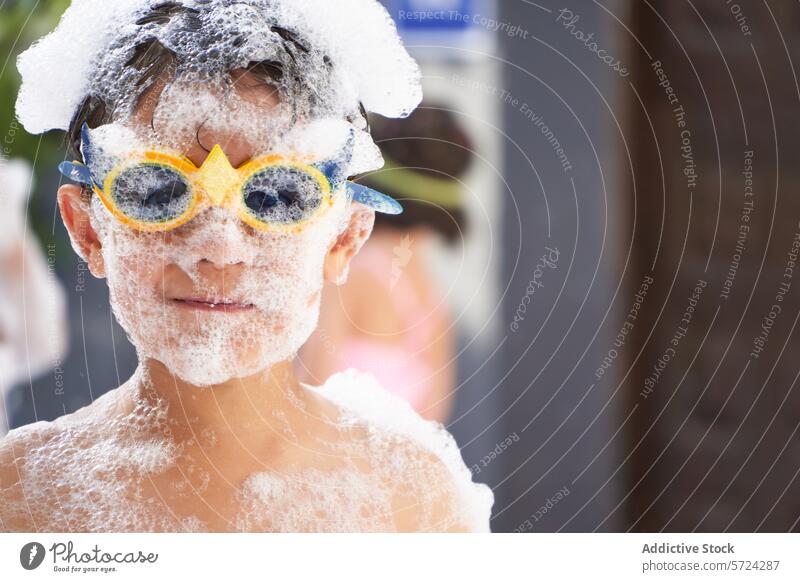 Fröhlicher Junge auf einer Party mit Schaum bedeckt Kind schäumen Spaß spielerisch Sonnenbrille Freude Fröhlichkeit Feier weiß Freizeit Aktivität Veranstaltung
