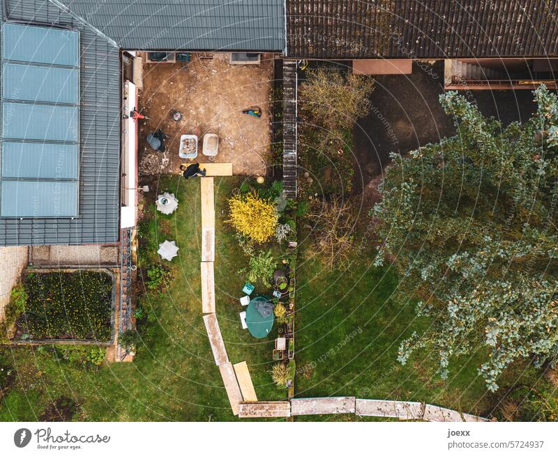 Eine neue Terrasse für den Frühling von oben Vogelperspektive bohlenweg renovieren Haus Garten Sand Dach Solaranlage Weg Reihenhaus bauen Gebäude Schubkarre