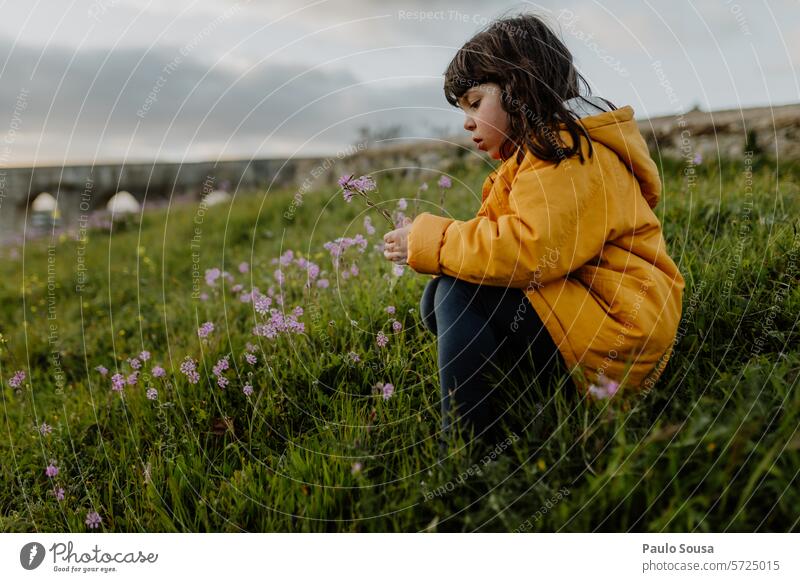 Niedliches Mädchen mit gelber Jacke pflückt Blumen 6 bis 7 Jahre Kind authentisch Kommissionierung Farbbild Foto Fotos Kinder Farbe 6-7 Personen Fotografie