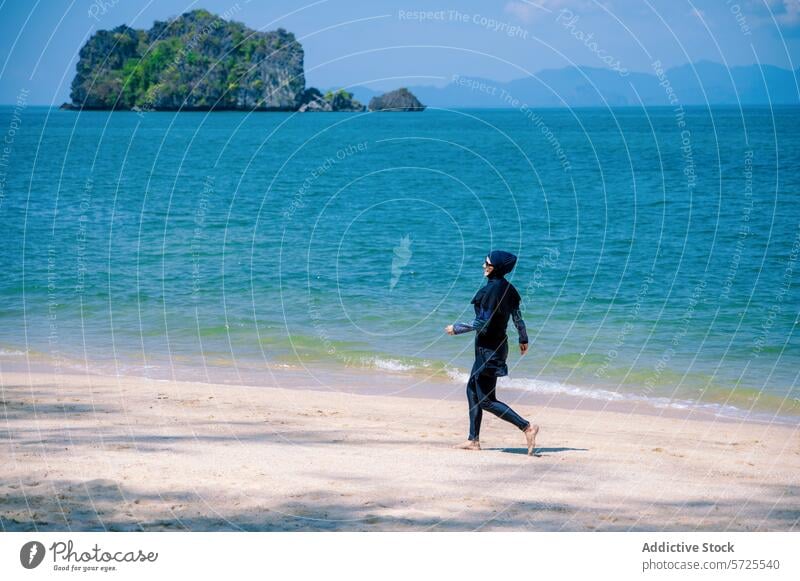 Frau im Burkini genießt einen Strandlauf burkini laufen MEER Insel Badebekleidung bescheiden muslimisch sonnenbeschienen Leichtathletik Sand Küstenstreifen blau