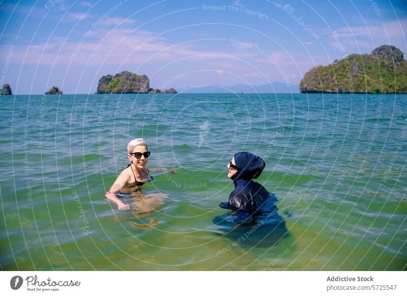 Zwei Frauen aus verschiedenen Kulturen genießen gemeinsam das Meer burkini Bikini MEER schwimmen kulturell Vielfalt Freundschaft Wasser Strand Insel malerisch