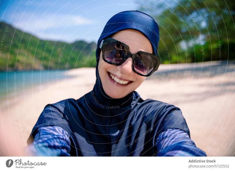 Lächelnde Frau im Burkini genießt den Strand burkini Selfie Badebekleidung bescheiden muslimisch sonnig Sand Hügel Mode Genuss im Freien Küstenstreifen Sommer