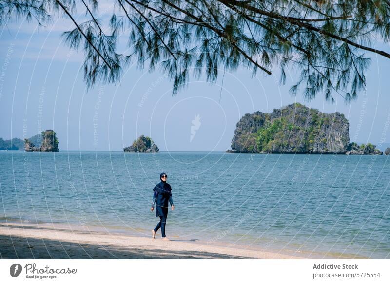 Muslimische Frau im Burkini genießt einen Tag am Strand muslimisch burkini MEER Insel Badebekleidung bescheiden Schatten Baum schlendern laufen Küstenlinie