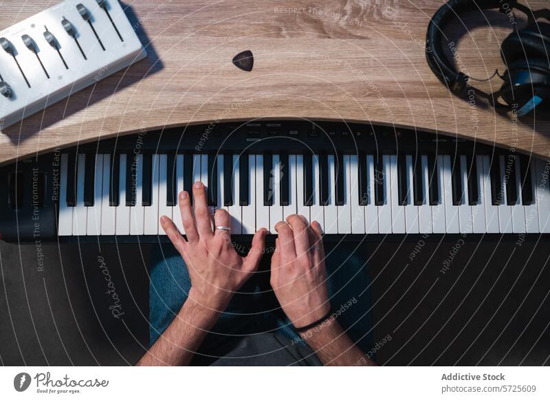 Draufsicht auf die Hände beim Spielen einer elektronischen Tastatur im Studio Musiker Keyboard Klang Atelier Sitzung Inszenierung Aufnahme Gerät Mixer Kopfhörer